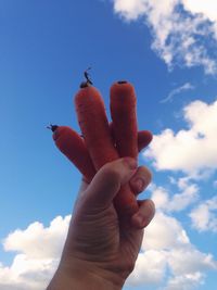 Low angle view of cropped hand against clear sky