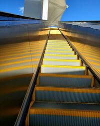 Low angle view of escalator against sky