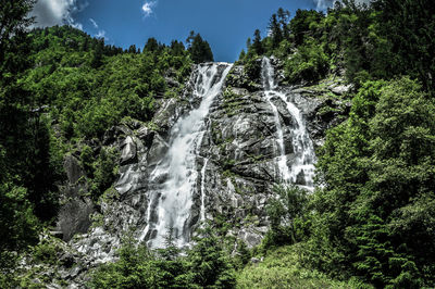 Low angle view of waterfall against sky