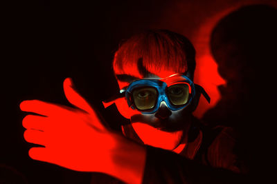 Close-up portrait of boy wearing illuminated goggles