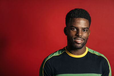 Portrait of young man against red background