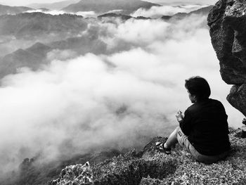 High angle view of hiker sitting on rock formation