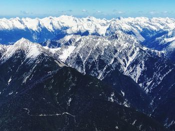 Aerial view of snowcapped mountains against sky