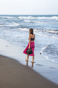 Rear view of woman walking on beach