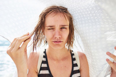Close-up portrait of girl with wet hair at beach