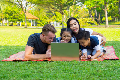 Happy family using laptop at park