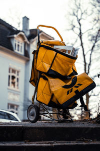 Close-up of yellow car on street against buildings