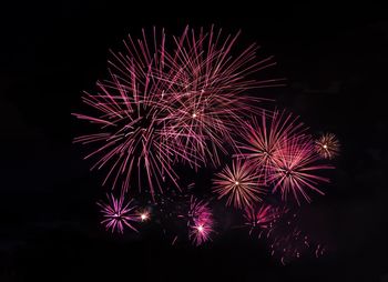 Low angle view of firework display at night