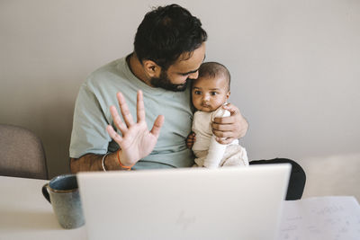 Father with baby working from home