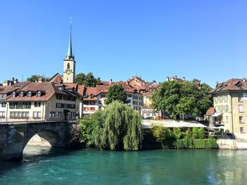 Buildings by river against sky