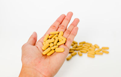Close-up of hand holding food against white background
