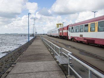 Train on pier at sea with cloudy sky, dagebuell, germany