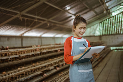 Portrait of young man standing in factory