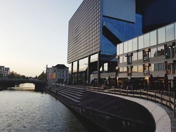 Canal amidst buildings against clear sky in city