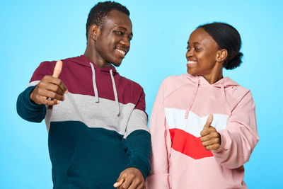 Couple standing against colored background