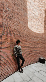 Full length of man leaning on wall