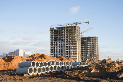 Construction site by buildings against sky