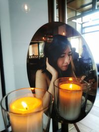 Young woman holding illuminated candle