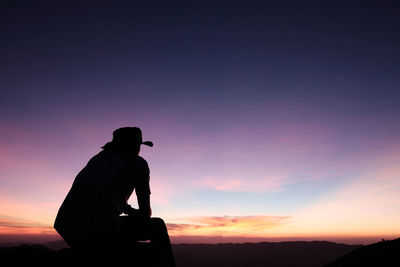 Silhouette man standing against sky during sunset