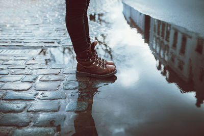 Low section of person standing on puddle