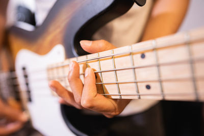 Midsection of man playing guitar