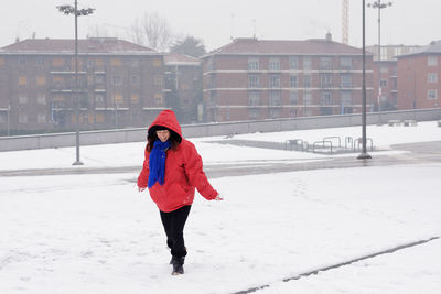 Full length of woman enjoying on snow covered field