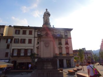 Statue in front of building against sky