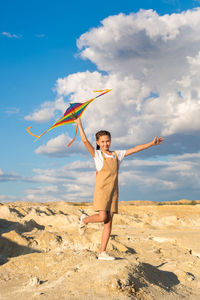 Portrait of a girl 8-9 years old with a kite standing on mountain.