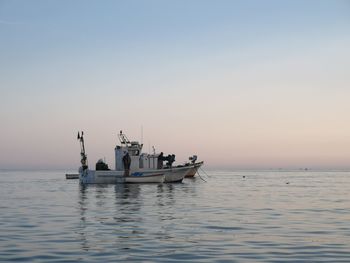 Boat sailing in sea against clear sky