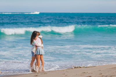 Rear view of woman standing at beach