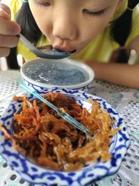 Close-up of girl eating food served on table