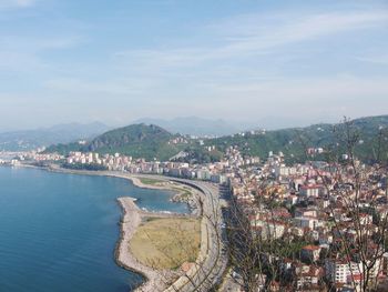 High angle view of townscape by sea against sky