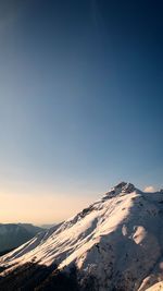 Scenic view of snowcapped mountains against clear sky