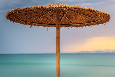 Traditional windmill on beach against sky