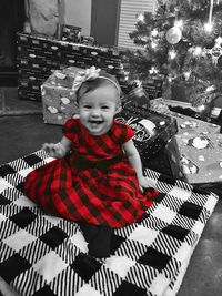 Full length of girl sitting on christmas tree