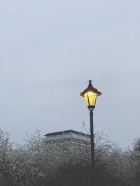 Low angle view of illuminated street light against sky