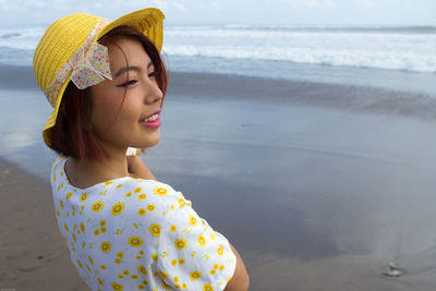 Smiling of woman wearing hat on beach