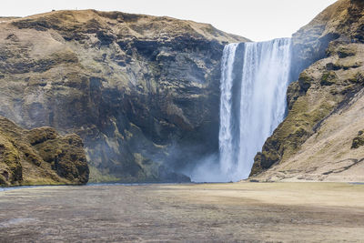 Scenic view of waterfall against sky