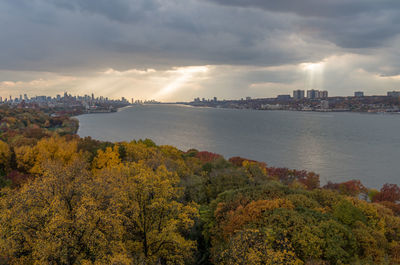 Scenic view of trees and buildings against sky during autumn