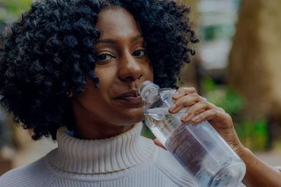 Close-up portrait of a serious young woman drinking glass