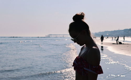 Side view of woman standing on shore at beach