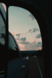 Reflection of sky on side-view mirror of car