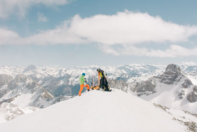 Side view of unrecognizable athletes talking on snow during trip on pico aunamendi in pyrenees mountains in navarre spain