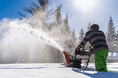 Rear view of man on snow against sky