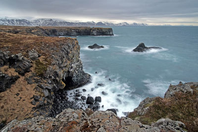 Scenic view of rocks in sea against sky