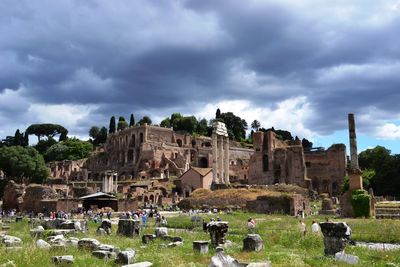 Old ruins on field against cloudy sky