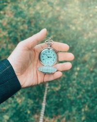 Close-up of hand holding clock