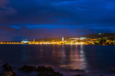 Scenic view of illuminated sea against sky at night