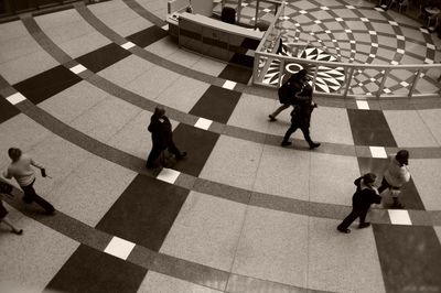 High angle view of people walking on patterned flooring