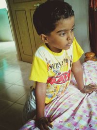 Cute girl sitting on bed at home